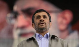 Iranian President Mahmoud Ahmadinejad standing before a portrait of the supreme leader, Ayatollah Ali Khamenei (Vahid Salemi/AP)