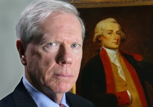 Paul Craig Roberts in front of a portrait of Alexander Hamilton, the first Secretary of the Treasury.