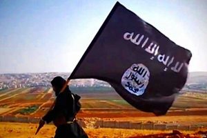 A militant carries the flag of the Islamic State, or ISIS (VOA)