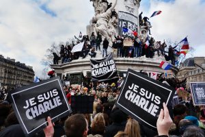 People hold up signs reading "JE SUIS CHARLIE", French for "I am Charlie" to express solidarity with the satire newspaper Charlie Hebdo at a rally in Paris, France, January 11, 2015 (Olivier Ortelpa/Flickr)