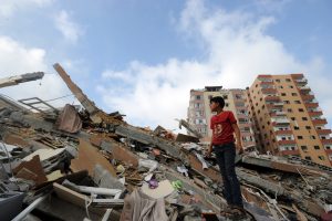 A Palestinian boy stands amid the rubble of a residential tower destroyed during Israel's 2014 assault on Gaza. (Shareef Sarhan/UN)