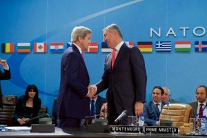 U.S. Secretary of State John Kerry shakes hands with Montenegrin Prime Minister Milo Djukanovic after signing an Accession Protocol to continue Montenegro's admission to the North American Treaty Organization amid the biannual Foreign Ministerial Meetings on May 19, 2016, at NATO Headquarters in Brussels, Belgium. (State Department/Public Domain)